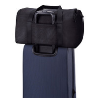 A black duffel bag rests on top of a dark blue suitcase, featuring straps and a handle.