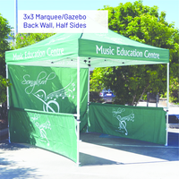 Green music education marquee gazebo with back wall and half sides in a sunny outdoor setting.