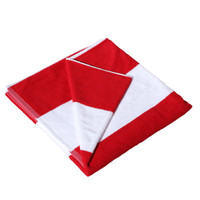 A red and white striped cotton beach towel, neatly folded and featuring a logo.