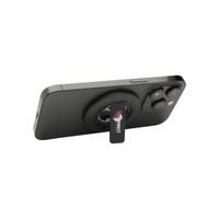 A magnetic phone stand in black, featuring a bottle opener and a logo, mounted on the back of a smartphone.