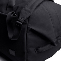 A black duffel bag featuring adjustable straps and a sleek design, with a logo on the side.