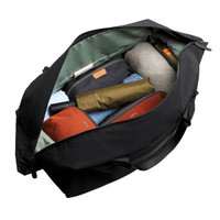 A black duffel bag open to reveal neatly packed items, including clothing and accessories in various colours.