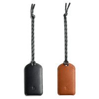 A set of two luggage tags, one in black leather and one in brown leather, with woven straps and a logo.