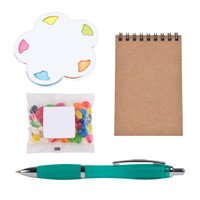 A colorful sticky note pad in a flower shape, a small bag of jelly beans, a spiral-bound notepad, and a turquoise pen.