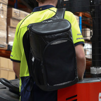 A black cooler backpack with a logo, worn by a person, featuring padded straps for carrying.