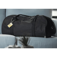 A black duffel bag rests on a light blue couch, featuring a zipper pocket and a tag.