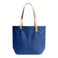 A blue tote bag with beige straps and a small logo. The bag features a simple, structured design.