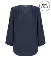 A navy blue V-neck popover shirt with long sleeves and pleated detailing. It features a logo in the corner.