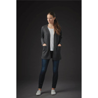 A woman wearing a dark grey Chelsea open cardigan over a white top, paired with dark jeans and casual white shoes.