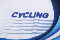 A close-up of a white cycling jersey featuring blue text and wave designs. The jersey includes a logo.