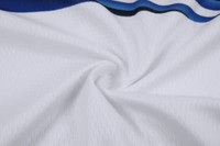 A close-up of white fabric with blue accents, featuring a textured pattern suitable for cycling team wear.