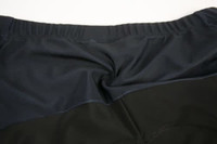 A close-up view of a cycling jersey featuring a dark navy and black design, with a logo on the back.