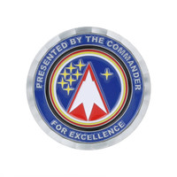 A round commemorative gold coin pin featuring a starry design and a red arrow symbol against a blue background.
