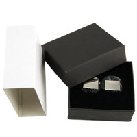 A pair of plain silver cufflinks displayed in a black box, with a white box beside it.