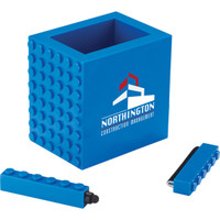 A blue pen pot designed to resemble building blocks, featuring a logo and two matching accessories.