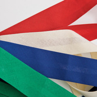 A collection of ribbon strips in red, white, blue, green, and cream laid out on a white background.