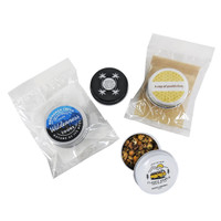 A collection of loose-leaf tea tins in black and white, alongside tea bags, enclosed in transparent packaging.