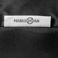 A close-up of a black fabric with a branded tag featuring the name "Marksman" stitched on it.