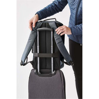 A grey Hedmark Commuter Backpack with padded straps being attached to a suitcase for easy transport.