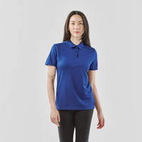 A woman poses in a blue Women's Apollo H2X-Dry Polo shirt, featuring short sleeves and a fitted style.