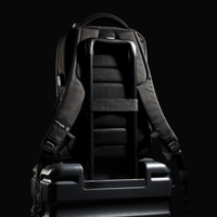 A black Swissdigital Arosa Backpack rests on a suitcase, featuring straps and a sleek design.