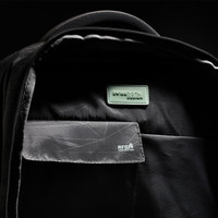 An interior view of a black backpack featuring compartments, a logo, and RFID protection detailing.