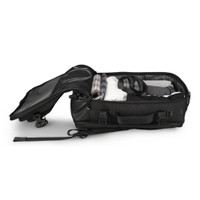 Open black travel bag packed with clothes and headphones.