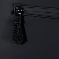 A close-up of a black backpack zipper with a fabric pull tab. The material appears water-resistant.