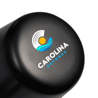 A black lamp with a rounded top featuring a logo design. The lamp is compact and rechargeable.