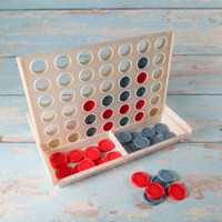 A Connect Four-style game featuring a wooden grid with red and grey discs, set against a rustic blue background.