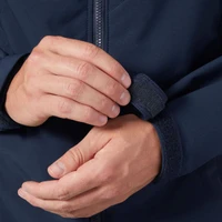 Adjustable navy jacket sleeve with Velcro strap being fastened by hands.
