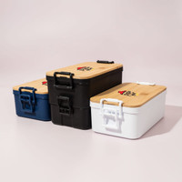 Three lunch boxes in navy, black, and white with bamboo lids and handles. All feature a logo on the top.