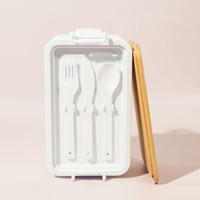 A white lunch box with a bamboo lid, featuring a fork, spoon, and knife inside. It has a simple, modern design.