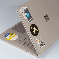 A silver laptop covered in various colourful stickers, including cartoon characters and logos.