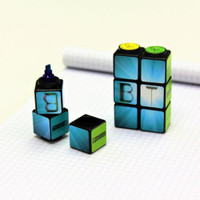 Unique cube highlighters on graph paper pad.
