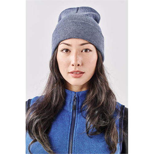 A dark blue knit beanie with a flexible, fitted design, worn by a person with long hair and a blue jacket. A dark blue knit beanie with a flexible, fitted design, worn by a person with long hair and a blue jacket.