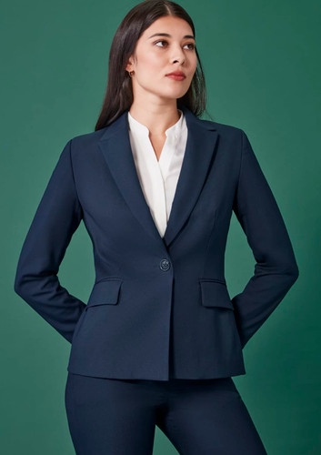 A navy single-button mid-length jacket with front pockets, styled with a white blouse. The model stands confidently against a green backdrop. A navy single-button mid-length jacket with front pockets, styled with a white blouse. The model stands confidently against a green backdrop.