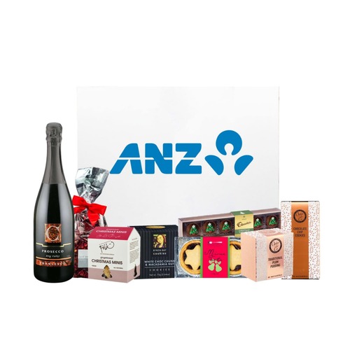 A festive hamper featuring Prosecco, assorted cookies, Christmas treats, and a pudding, presented in a branded box. A festive hamper featuring Prosecco, assorted cookies, Christmas treats, and a pudding, presented in a branded box.