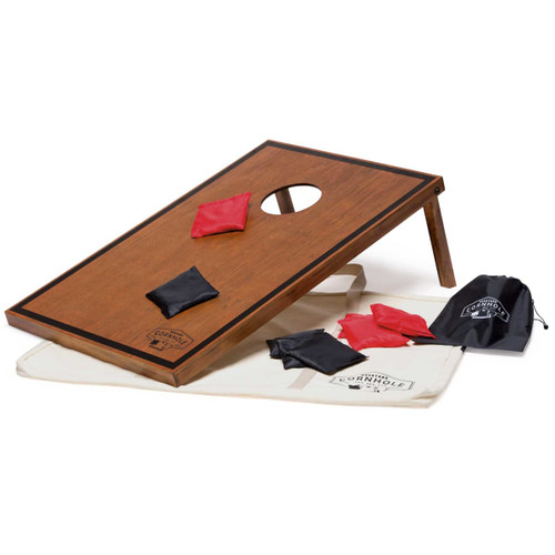 A wooden cornhole board in brown with a hole, red and black bean bags, and a carry bag in white. A wooden cornhole board in brown with a hole, red and black bean bags, and a carry bag in white.