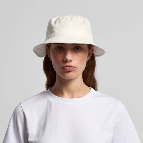 A white bucket hat with a soft brim, featuring a logo, worn by a model in a plain white T-shirt.
