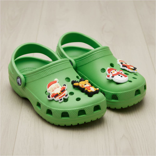 A pair of green crocs featuring festive shoe charms, including Santa and a reindeer. A pair of green crocs featuring festive shoe charms, including Santa and a reindeer.