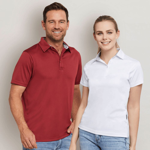 Man in red polo shirt and woman in white polo shirt smiling.