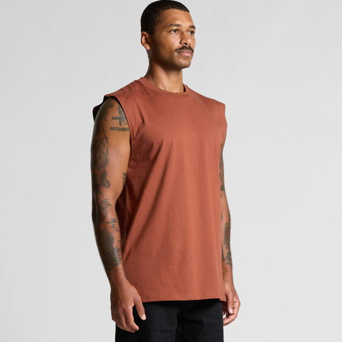 A man displaying a rust-coloured classic tank top with sleeveless design and a subtle logo. A man displaying a rust-coloured classic tank top with sleeveless design and a subtle logo.