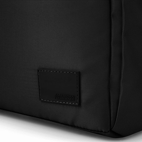 A black duffle bag with a smooth texture and a branding label on the side.