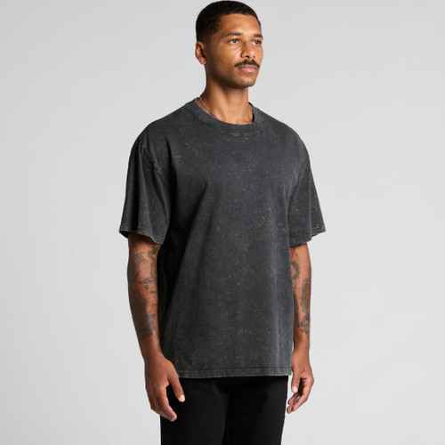 A man wearing a stone wash heavy tee in black, standing against a plain background. The shirt has a relaxed fit.