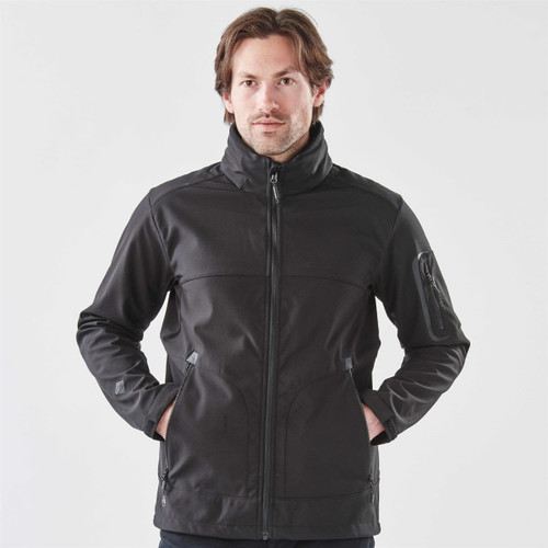 A men's black softshell jacket with a full zip, featuring zippered pockets and a stand-up collar.