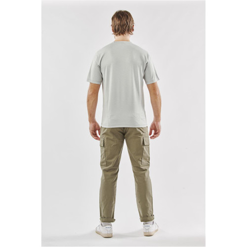 A man wearing a light grey T-shirt and khaki pants, standing with his back to the camera. The shirt features a logo.