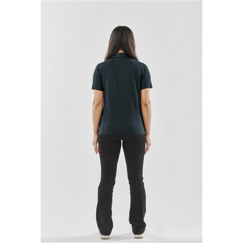 A woman wearing a black polo shirt stands with her back to the viewer, paired with black pants. The shirt has a logo.