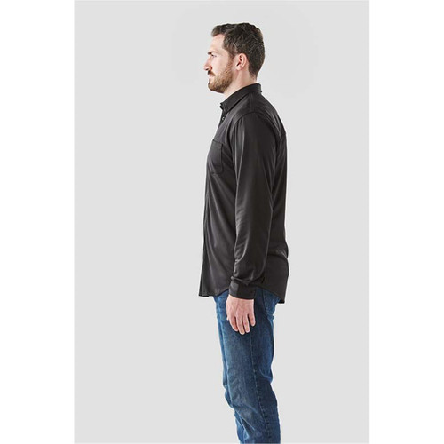 A men's long sleeve button-up shirt in black, featuring a pocket and a logo, displayed on a model from the side.