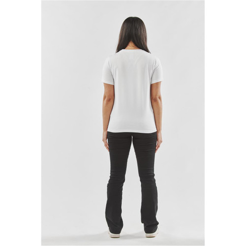 A white women's tee viewed from the back, paired with black pants. The shirt has a fitted design.